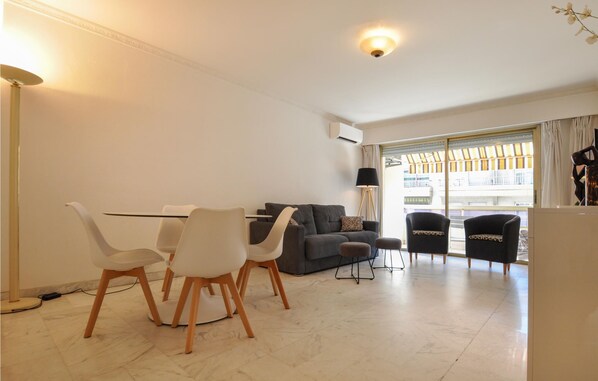 A modern living room with a sofa, chairs, a coffee table, and a large window with a view. - 1 bedroom awesome apartment in Cannes (Cannes)