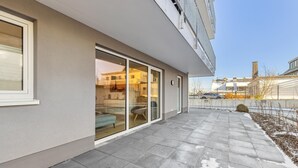 A modern building with a covered patio, large sliding glass doors, and a view of the surrounding area. - GebirgsResort Winterberg (Winterberg)