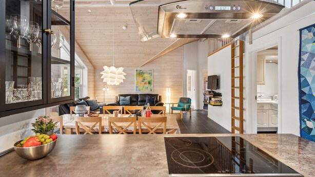 A modern kitchen with a built-in stove, wooden ceiling, and a dining area with a sofa and chairs. - Gorgeous home in Glesborg with WiFi (Glesborg)