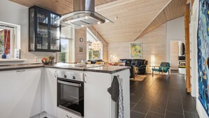 A modern kitchen with a central island, built-in oven, and a large window. - Gorgeous home in Glesborg with WiFi (Glesborg)