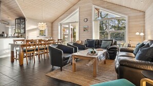 A spacious living area with a high ceiling, a dining area with wooden furniture, and large windows providing natural light. - Gorgeous home in Glesborg with WiFi (Glesborg)