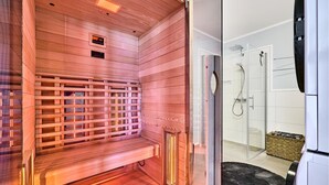 A sauna with a wooden bench and a glass door leading to a shower area. - Gorgeous apartment in Winterberg (Winterberg)