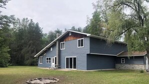 A two-story house with a large front yard and a fire pit. - The Getaway Cabin W/ Indoor hot tub and sauna.
 (Alger)
