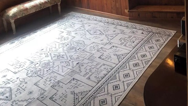 A wooden cabin interior with a hot tub, large windows, a bench, and a patterned rug. - The Getaway Cabin W/ Indoor hot tub and sauna.
 (Alger)
