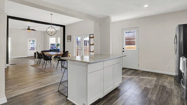 A spacious kitchen with a central island, wooden flooring, and a ceiling fan. - Beautiful 3500 SqFt Villa in Fountain Sq (Indianapolis)
