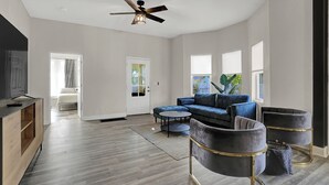 A spacious living room with a sectional sofa, two armchairs, a coffee table, and a ceiling fan. - Beautiful 3500 SqFt Villa in Fountain Sq (Indianapolis)