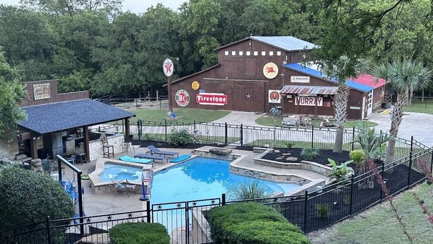 A hotel with a swimming pool, outdoor seating, and a fenced patio area. - Texan barn apartment awaits your arrival ! (Waxahachie)