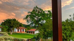 Une maison traditionnelle avec un toit rouge, entourée d’une végétation luxuriante et d’une pelouse bien entretenue.