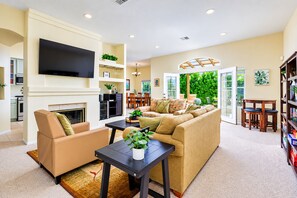 A living room with a fireplace, sofa, and television.
