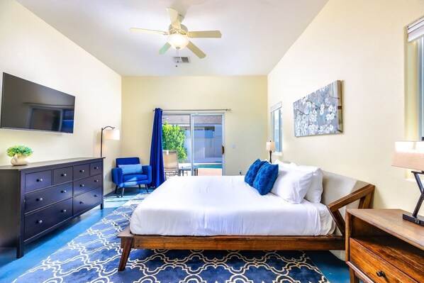 Une chambre d’hôtel avec un lit, une télévision, un bureau, une chaise et un balcon avec vue.