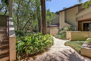 Stroll through lush gardens to a serene retreat with an entrance.