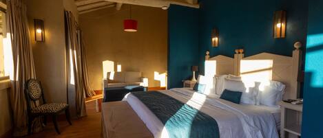 A hotel room with a large bed, a chair, and a nightstand.