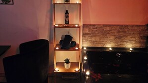 Un salon avec une bibliothèque en bois, un fauteuil noir et une cheminée.
