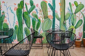Enjoy meals in a lively dining area with a vibrant mural and comfortable seating for three.
