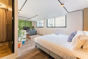 Relax in a spacious room with a large bed, a cozy seating area, and a flat-screen TV.