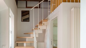 A staircase with wooden steps and white railings leading to a second-floor balcony. - Exquisite Historical Villa in Rome..,Where Elegance Meets History (Roma)