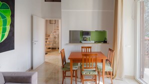 A spacious living area with a dining table, chairs, a sofa, a ceiling fan, and a large window. - Exquisite Historical Villa in Rome..,Where Elegance Meets History (Roma)