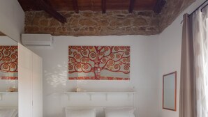 A bedroom with a large bed, a stone wall, and a wooden ceiling. - Exquisite Historical Villa in Rome..,Where Elegance Meets History (Roma)