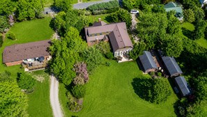 An aerial view of a residential area with multiple houses, a well-maintained lawn, and a clear road. - The Elderberry Studio (Wanchese)