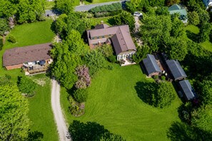 An aerial view of a residential area with multiple houses, a well-maintained lawn, and a clear road. - The Elderberry Studio (Wanchese)