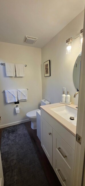 Une salle de bain équipée de toilettes, d’un lavabo et d’un porte-serviettes.