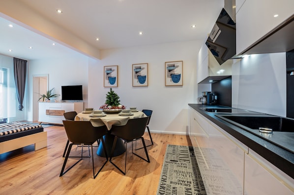 Un espace de vie moderne comprenant un coin repas, une cuisine et un lit.