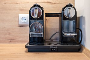Eine Kaffeemaschine mit Bedienfeld, einer Steckdose und einer Holzwand.