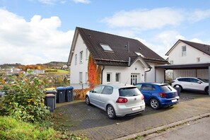 A residential area with houses, parked cars, and a clear sky.