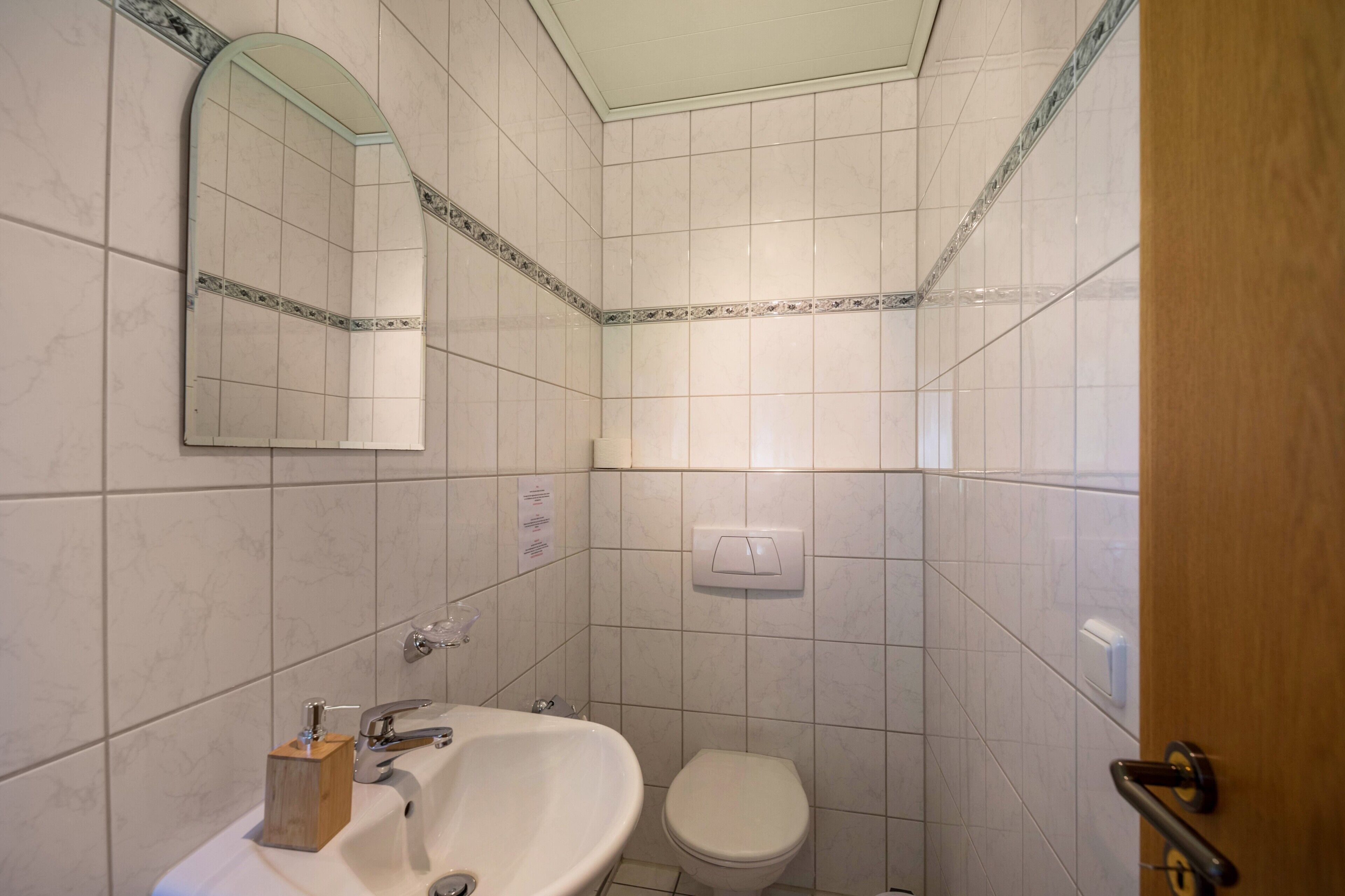 Ein Badezimmer mit Waschbecken, Spiegel und Toilette.