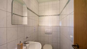 Ein Badezimmer mit Waschbecken, Spiegel und Toilette.