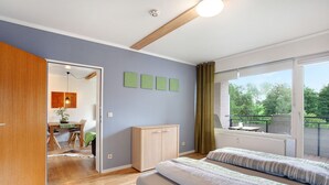 Una camera da letto con un letto, una scrivania e vista sull'esterno.