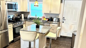 A modern kitchen with a central island, stainless steel appliances, and a pendant light. - Cozy 2BR Retreat with Free Parking & Prime Location (Baltimore)