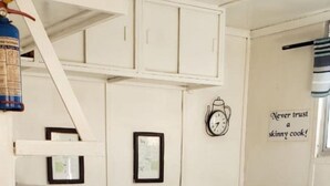 A compact kitchen with white cabinets, a black countertop, a sink, and a clock on the wall. - Houseboat With Aircon and Splash Pool - 2128 (Kariba)