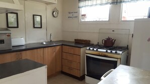A kitchen with wooden cabinets, a gas stove, a microwave, and a sink. - Houseboat With Aircon and Splash Pool - 2128 (Kariba)
