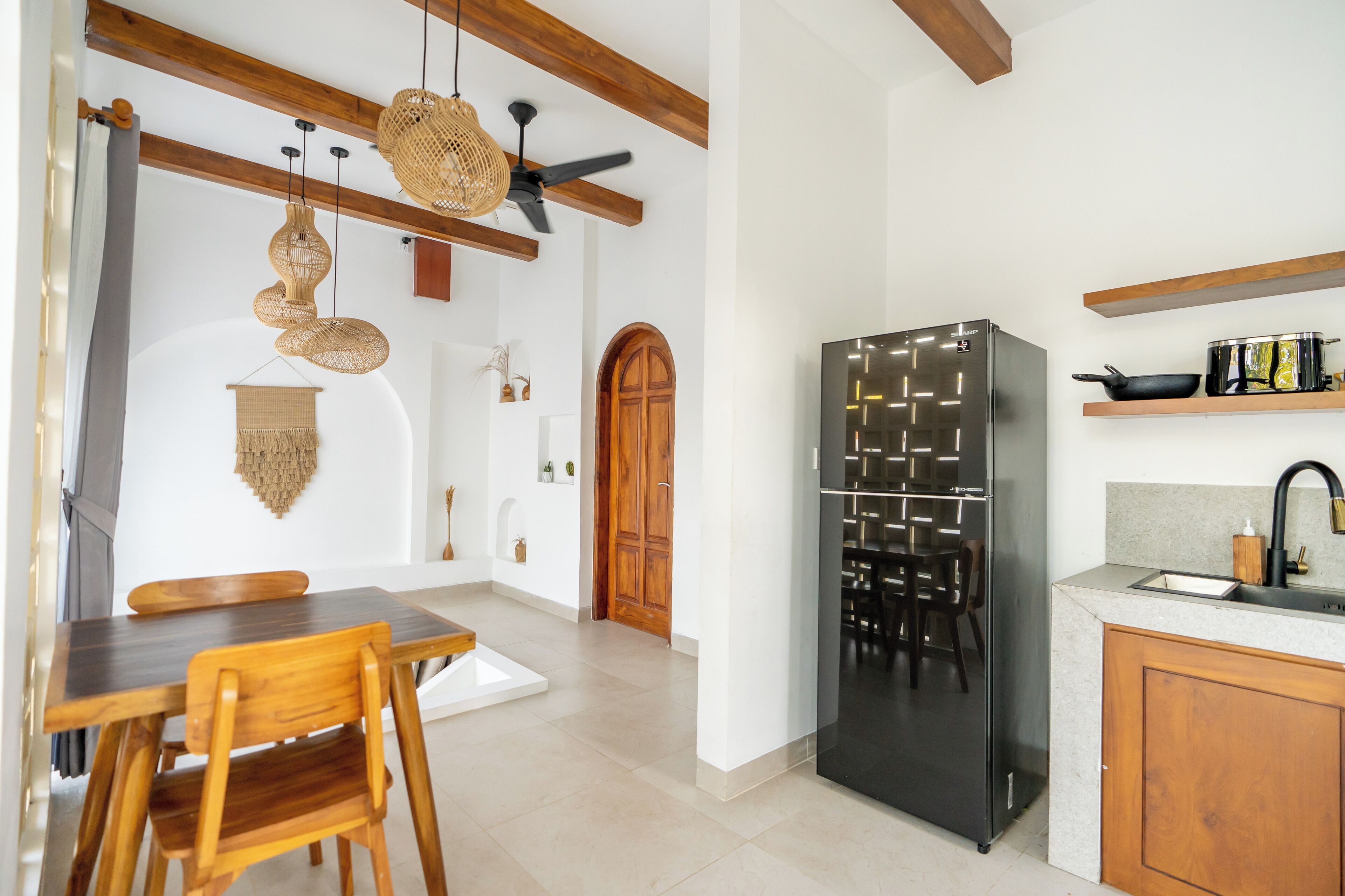 A modern kitchen with a built-in refrigerator, wooden cabinets, and a dining area with a table and chairs.