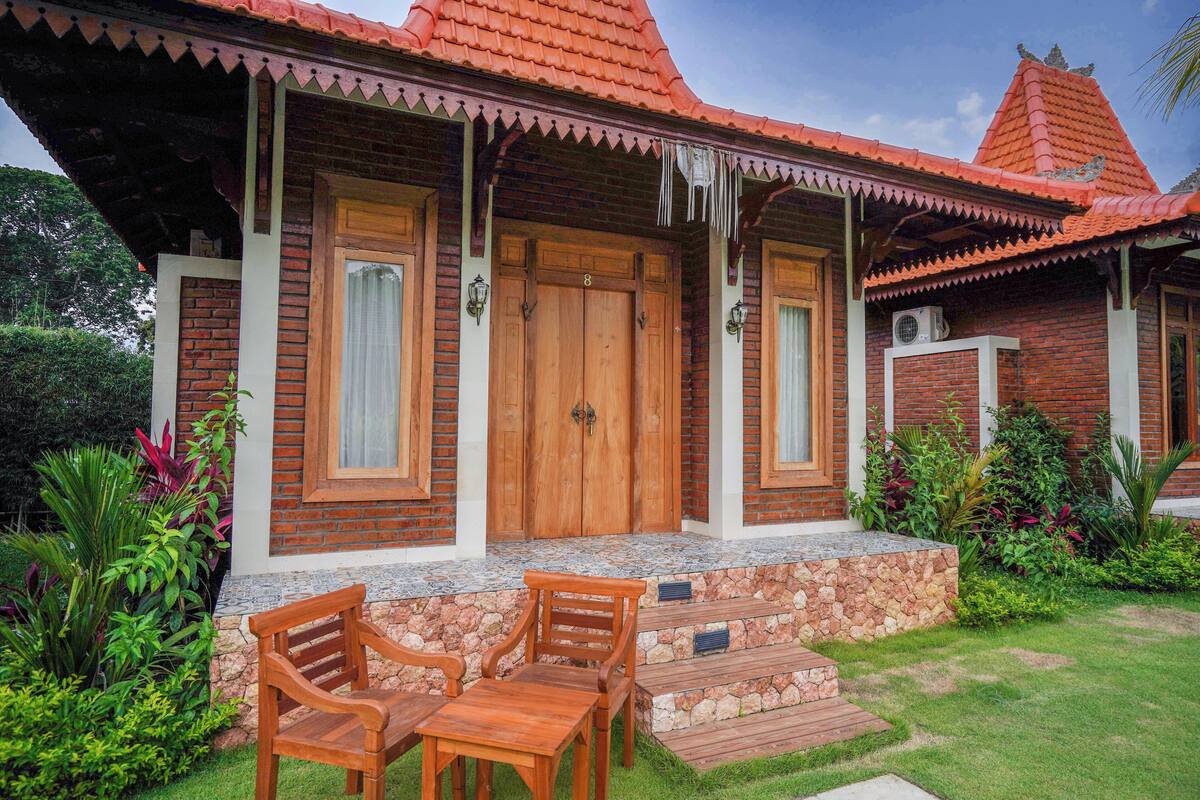 A traditional house with a tiled roof, wooden doors, and a stone staircase leading to the entrance.
