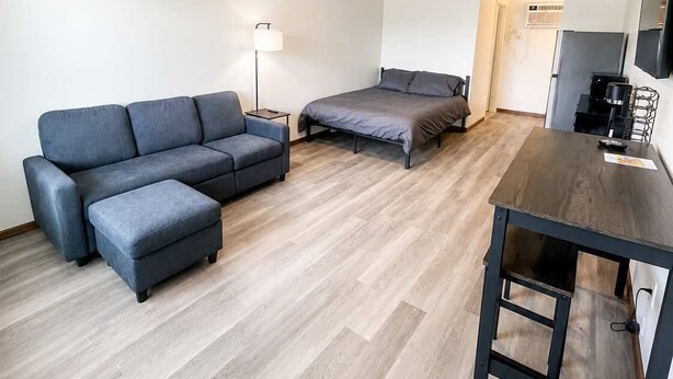 A modern, minimalistic room with a sofa, a bed, a small table, and a TV. - Stand Rock Studios in Wisconsin Dells! (Wisconsin Dells)