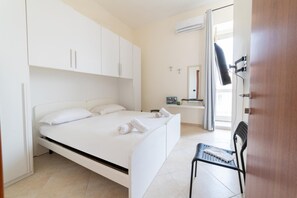 A modern bedroom with a bed, a chair, and a bathroom visible through an open door. - Piazza Garibaldi 39 in Naples (Naples)