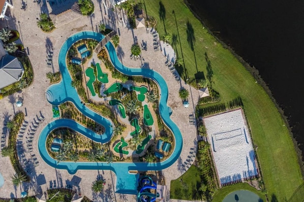 Vue aérienne d’un complexe hôtelier doté d’une grande piscine, de plusieurs toboggans aquatiques et d’une plage.