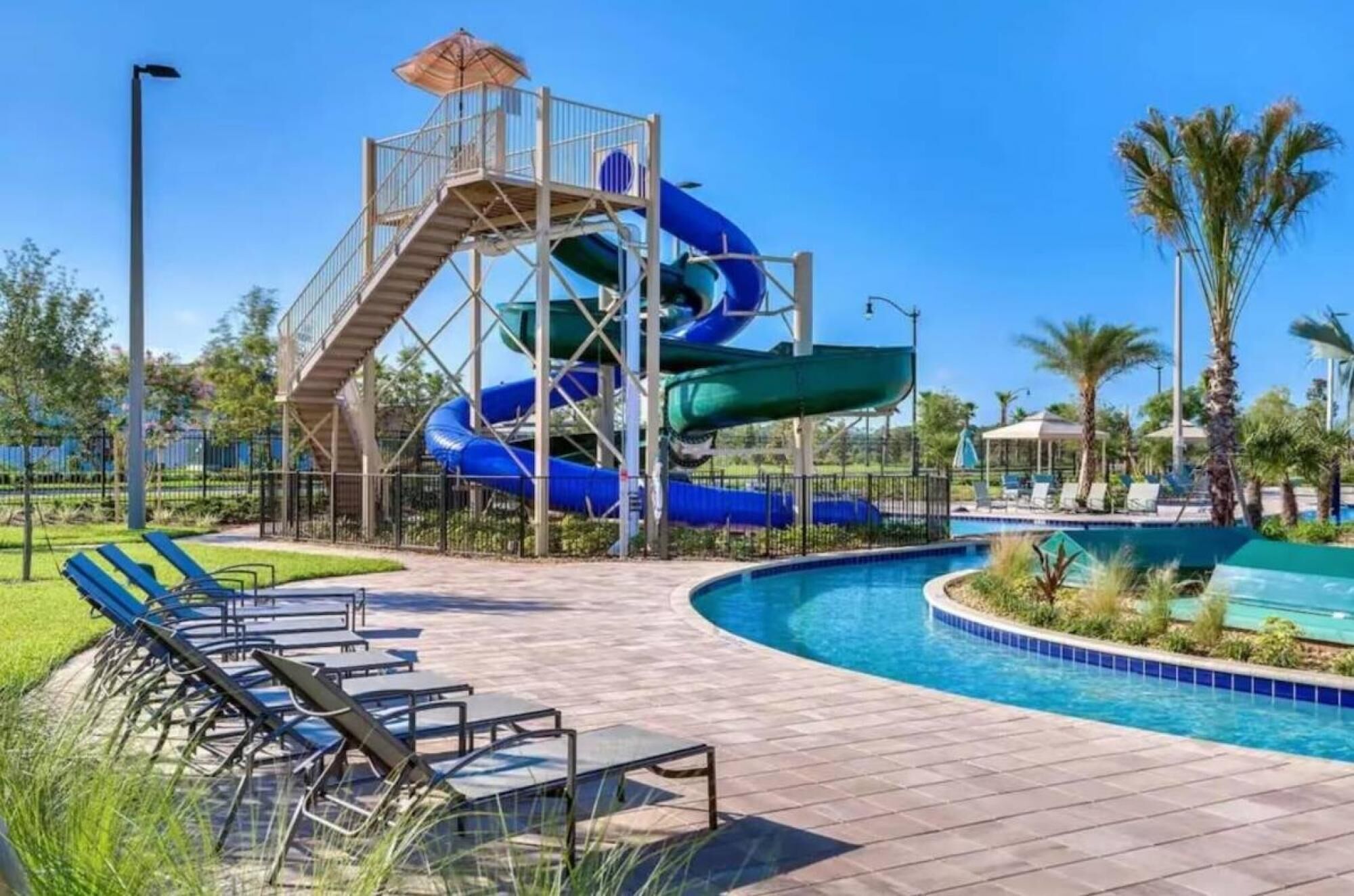 A water park with multiple slides, a pool, and lounge chairs.