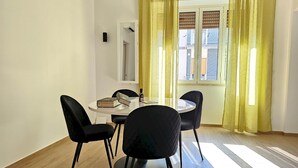 En matplats med ett runt bord, fyra svarta stolar, en bok och en flaska.