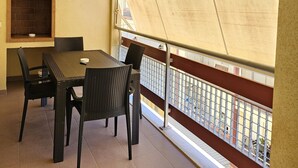 A balcony with a table and chairs, a brick fireplace, and a view of the city through a large window. - Casa Calette in Monopoli (Monopoli)
