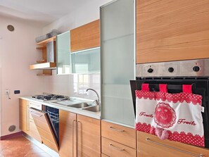 A modern kitchen with wooden cabinets, a stainless steel stove, and a built-in oven.
