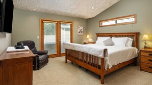 Un dormitorio con cama, escritorio, silla, ventana e iluminación empotrada en el techo.