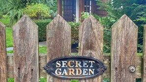 A wooden gate with a sign that reads "SECRET GARDEN." - Sit Back & Watch Waves at Rathtrevor Cottage (Parksville)