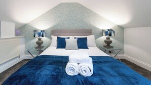 Una camera da letto con un letto, due comodini, un termosifone e una parete con motivo decorativo.
