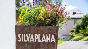 A planter with the text "SILVAPLANA" in a rustic metal container, surrounded by colorful flowers. - Chesa Dal Luf B1 by Interhome (Silvaplana-Surlej)