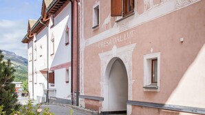 A building with a pink facade and a white archway, labeled "CHESIA DAL LVF." - Chesa Dal Luf B1 by Interhome (Silvaplana-Surlej)