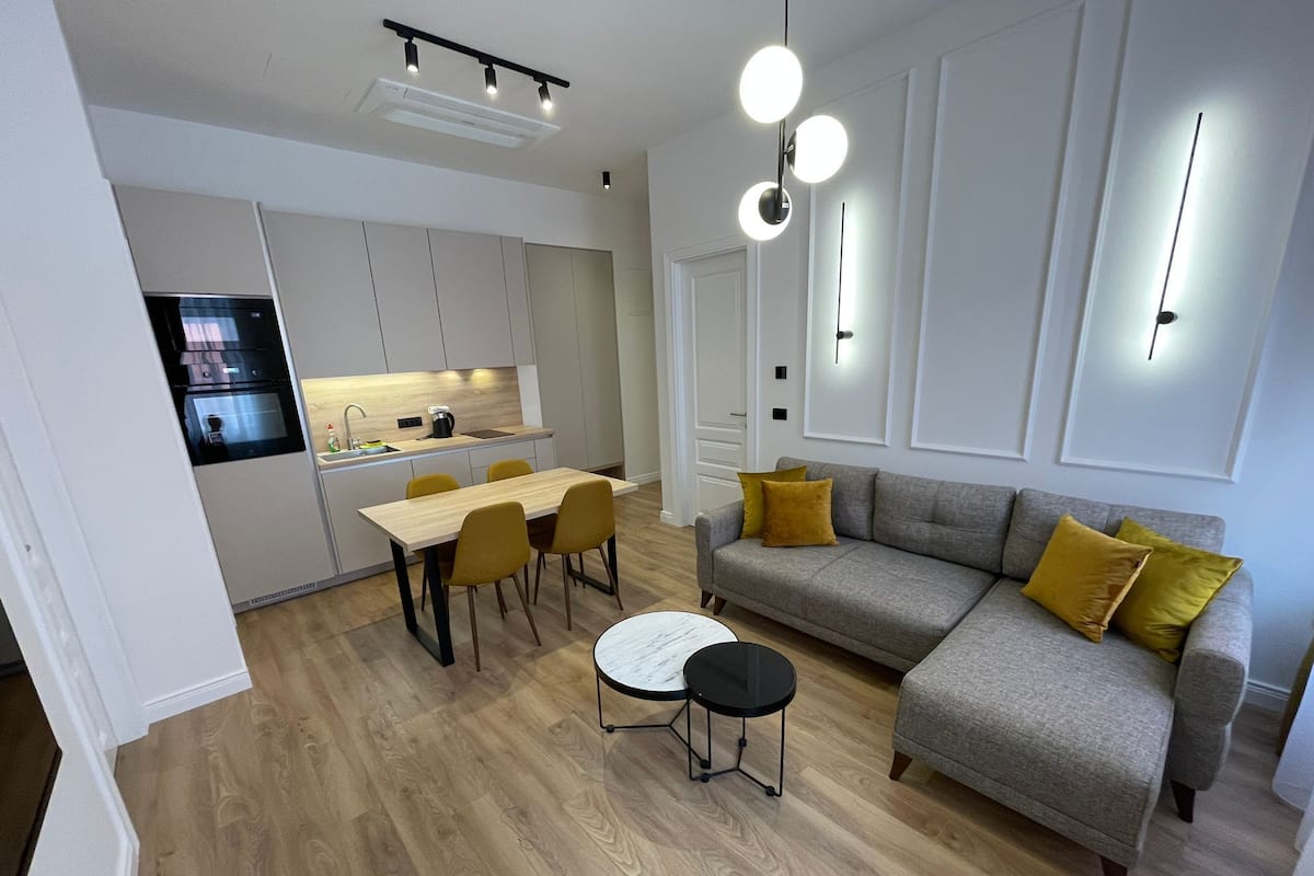En moderne lejlighed med køkken, spiseplads og opholdsstue.