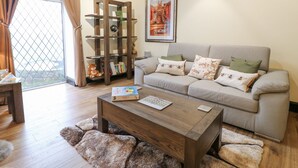 Un salon avec un canapé, une table basse et une bibliothèque en bois.